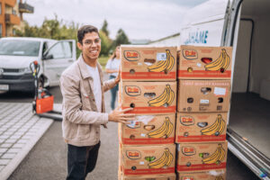 A student unpacking products from a van.